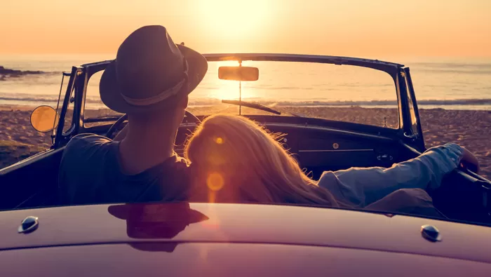 couple enjoying sunset in classic car