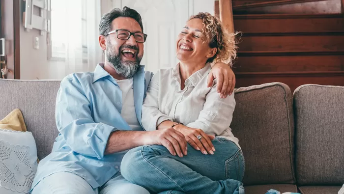 happy couple sitting on couch enjoying life