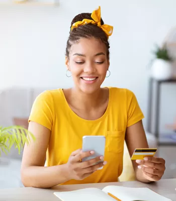 young woman on couch using visa credit card