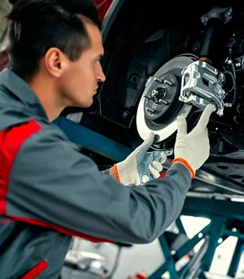 man replacing brakes on a car