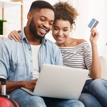 younger couple shopping on computer with credit card
