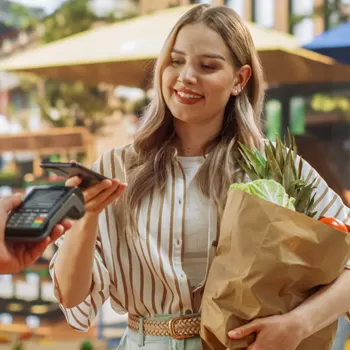 young woman using digital wallet to make purchase at store