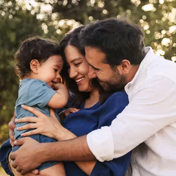 happy family in field hugging