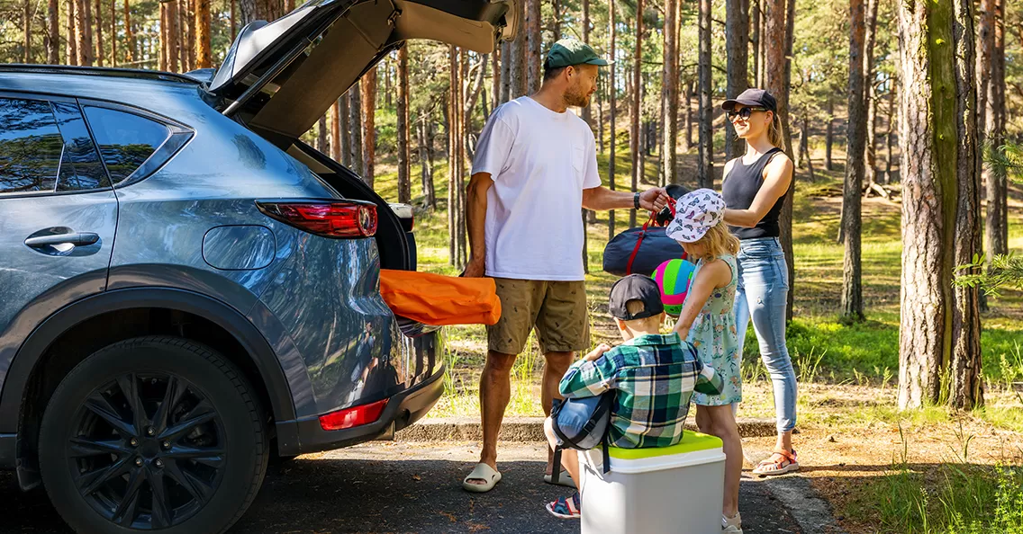 happy family emptying car on trip