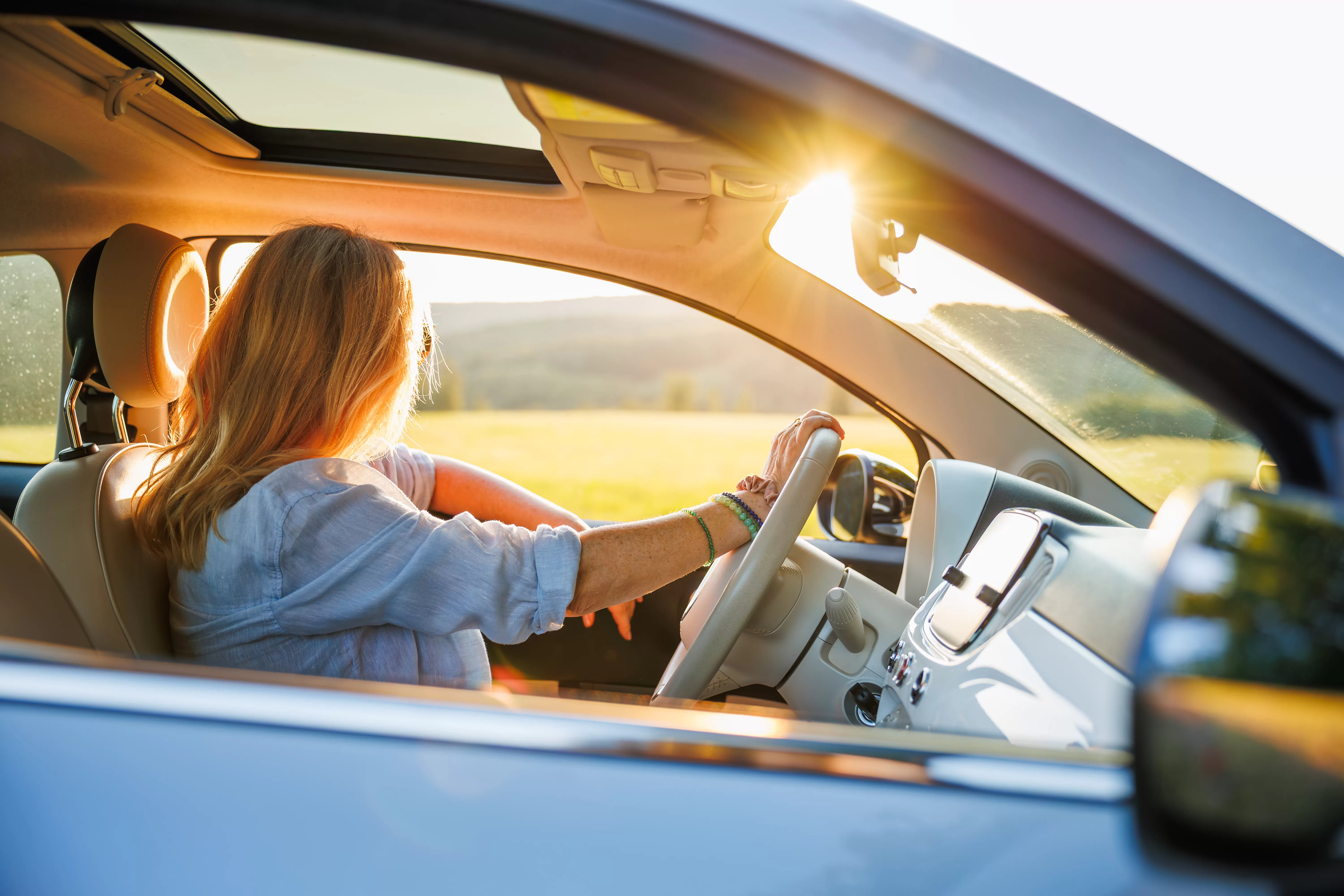 woman in car with sunsetting